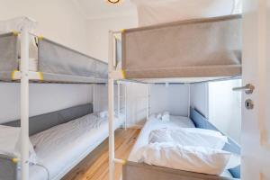 2 Etagenbetten in einem Zimmer mit Holzböden in der Unterkunft Cozy Coastal Getaway 3BR Apartment in Estoril in Estoril
