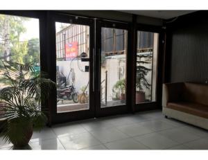 un soggiorno con porte in vetro e una pianta di Hotel Alpine, Kurukshetra a Kurukshetra