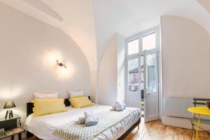 a bedroom with a bed with yellow pillows at Appartement immeuble le bringer 180m2 in Marvejols