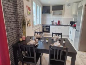 a kitchen with a table and chairs and a kitchen with white appliances at Superbe appartement 2 pièces - Aix-les-Bains Riviera des Alpes - Parking gratuit in Aix-les-Bains