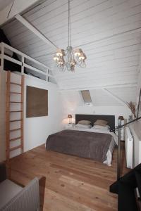 a bedroom with a bed and a chandelier at De Peirdestal in Pittem