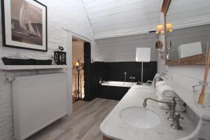 a bathroom with a sink and a bath tub at De Peirdestal in Pittem