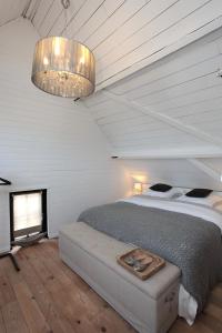 a bedroom with a bed and a chandelier at De Peirdestal in Pittem