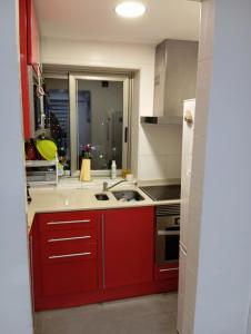 a kitchen with red cabinets and a stove top oven at Villa Juanmi in Magaluf