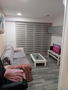 uma sala de estar com um sofá e uma televisão em Villa Juanmi em Magaluf