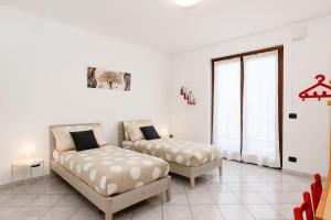 sala de estar con 2 camas y ventana en Casa Dany - Alba - Family Apartment, en Guarene