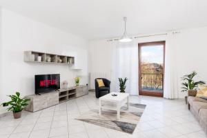 a living room with a couch and a tv at Casa Dany - Alba - Family Apartment in Guarene