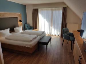 a hotel room with a bed and a chair at Hotel Waldhorn in Friedrichshafen