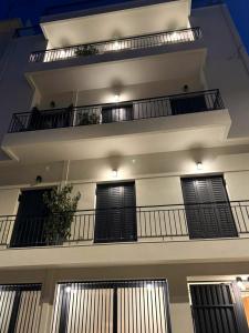 an apartment building with two balconies with black doors at AIONION RESIDENCES by K&K in Athens