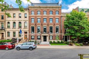 deux voitures garées devant un grand bâtiment en briques dans l'établissement Stylish Studio in Historic Boston - Unit #205, à Boston