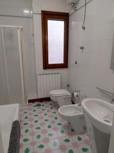 baño con 2 aseos y lavamanos en Casa Bianca Luce, en Torre Santa Susanna