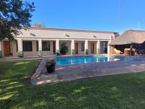 a house with a swimming pool in the yard at Molopo Naledi Guest Lodge in Vryburg