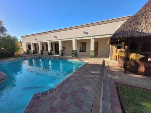 a swimming pool in front of a building at Molopo Naledi Guest Lodge in Vryburg