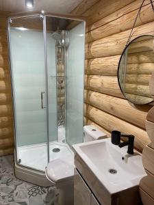 a bathroom with a glass shower and a sink at Вілла Розмарія in Yaremche