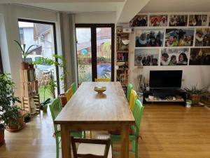 uma sala de jantar com uma mesa de madeira e cadeiras verdes em B&B San Michele em Baia Mare