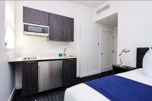 a hotel room with a bed and a kitchen at Modern Studio in Historic Boston - Unit #303 in Boston