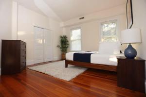 a bedroom with a bed and a dresser with a lamp at Stylish Apartment in Malden 20 Min from Boston #2 in Malden