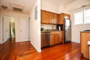 a kitchen with wooden cabinets and a stainless steel refrigerator at Stylish Apartment in Malden 20 Min from Boston #2 in Malden