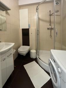 a bathroom with a sink and a toilet and a shower at Fancy Life Apartment in Warsaw