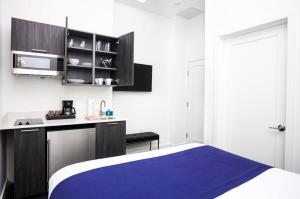 um quarto com uma cama e uma cozinha com armários em Stylish Studio in Fenway Neighborhood - Unit #203 em Boston