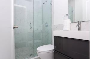 a bathroom with a toilet and a glass shower at Modern Studio in Historic Boston - Garden Unit #1 in Boston