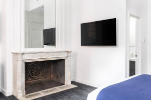 a bedroom with a fireplace and a tv on a wall at Stylish Studio in Historic Boston - Unit #204 in Boston