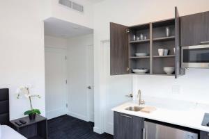 a kitchen with white walls and wooden cabinets at Modern Studio in Historic Boston - Unit #302 in Boston