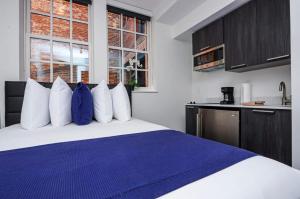 a bedroom with a bed with blue and white pillows at Modern Studio in Historic Boston - Garden Unit #4 in Boston +11 photos