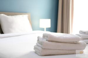 a pile of white towels sitting on a bed at Ta' Tereża Seafront Apartments in St Julian's