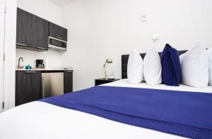 a bedroom with a large bed with blue and white pillows at Modern Studio in Historic Boston - Unit #103 in Boston