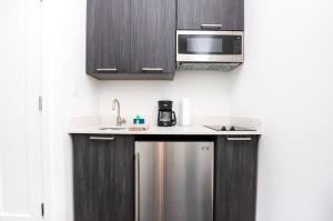 a kitchen with a stainless steel refrigerator and a microwave at Modern Studio in Historic Boston - Unit #103 in Boston