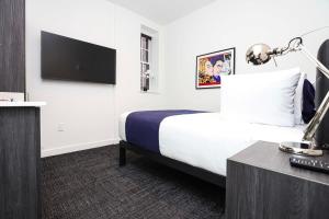 a hotel room with a bed and a tv at Stylish Studio in Fenway Neighborhood - Unit #305 in Boston