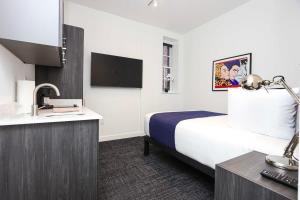 a hotel room with a bed and a sink at Stylish Studio in Fenway Neighborhood - Unit #305 in Boston