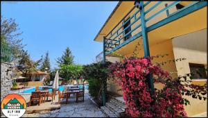 a resort with a pool and tables and flowers at Alp inn Butik Apart ve Restoran in Marmaris