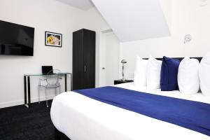 een slaapkamer met een groot bed met blauwe en witte kussens bij Stylish Studio in Historic Boston - Unit #405 in Boston