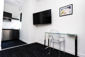 een kamer met een glazen tafel en een televisie aan de muur bij Stylish Studio in Historic Boston - Unit #405 in Boston +17 foto's
