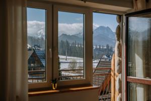 ザコパネにあるApartamenty widokowe Zakopaneの雪山の景色を望む窓