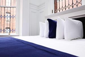 a bed with white and blue pillows and a window at Luxurious Studio in the Heart of Boston in Boston