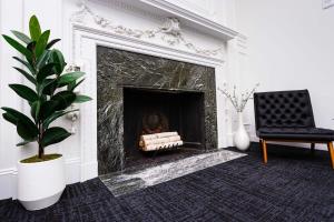 a living room with a fireplace and a black chair at Luxurious Studio in the Heart of Boston in Boston