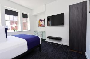 um quarto de hotel com uma cama e uma televisão de ecrã plano em Stylish Studio in Historic Boston - Unit #406 em Boston