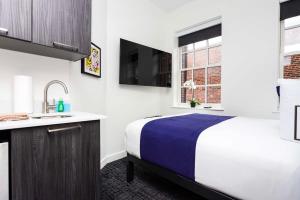 1 dormitorio con 1 cama, lavamanos y TV en Stylish Studio in Historic Boston - Unit #404, en Boston