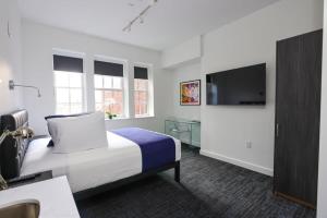 um quarto de hotel com uma cama e uma televisão em Stylish Studio in Historic Boston - Unit #406 em Boston