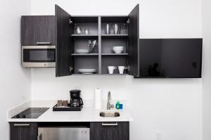 a kitchen with black cabinets and a sink at Modern Studio in Historic Boston - Unit #101 in Boston