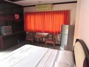 a room with a bed and a kitchen with a refrigerator at AA Guesthouse in Pattaya South