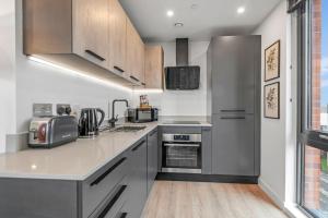 cocina con electrodomésticos de acero inoxidable y suelo de madera en Apartment 47 with secure Free parking, en York