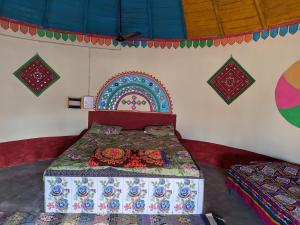 a bedroom with a bed with a colorful bedspread at Vijay Homestay in Dhordo