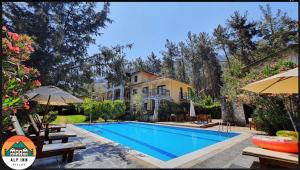 a villa with a swimming pool in front of a house at Alp inn Butik Apart ve Restoran in Marmaris