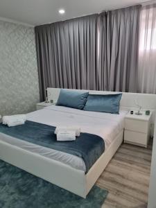 a bedroom with a large bed with blue pillows at Mikaela Guest House in Odivelas