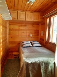 una camera con un letto in una cabina di legno di Holiday Home Samanitieva a Enontekiö