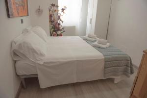 Una cama blanca con toallas en una habitación en Il Ragno D`Oro, en Rho